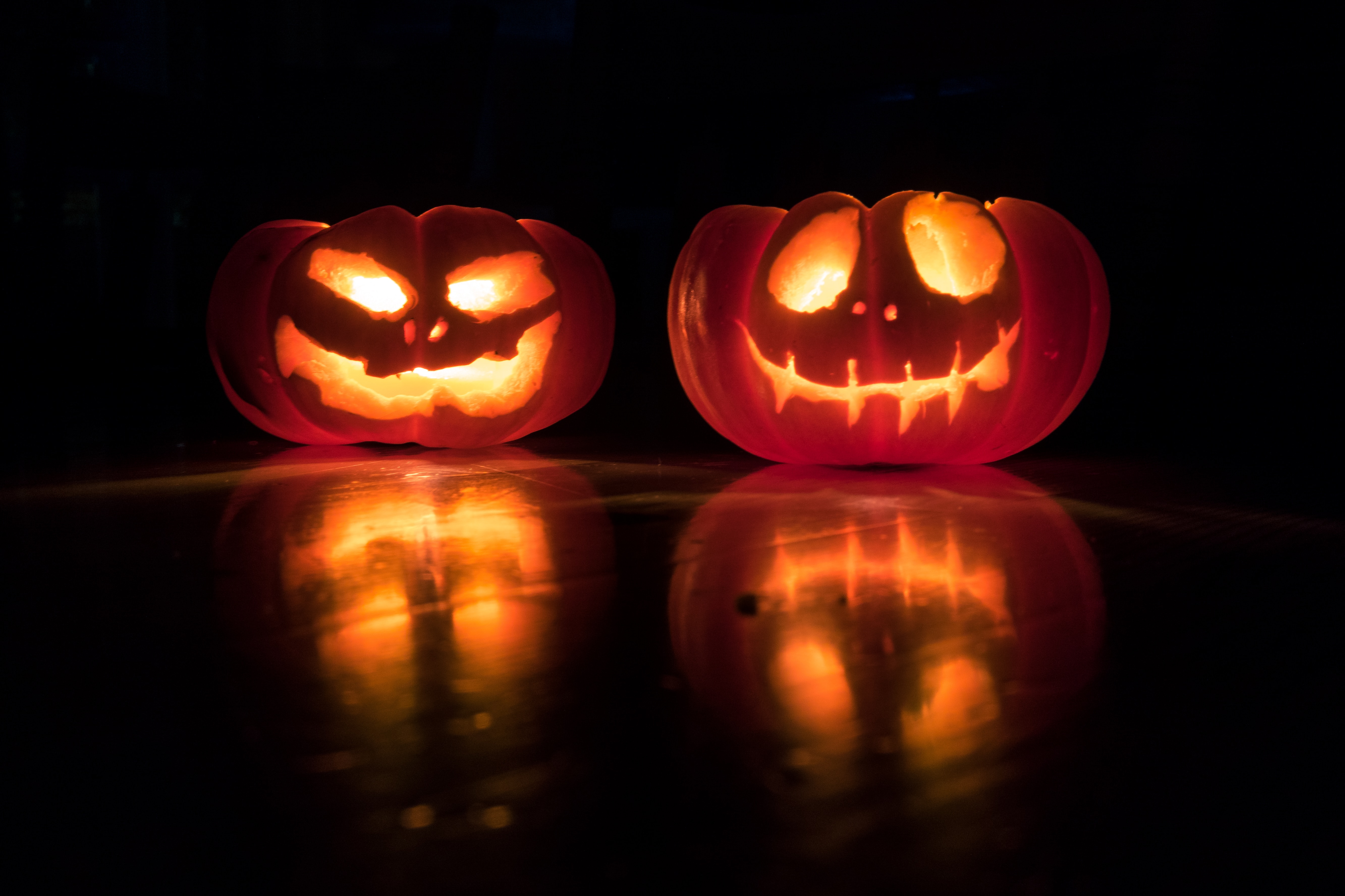 Two jack-o-lanterns lit up in the dark.